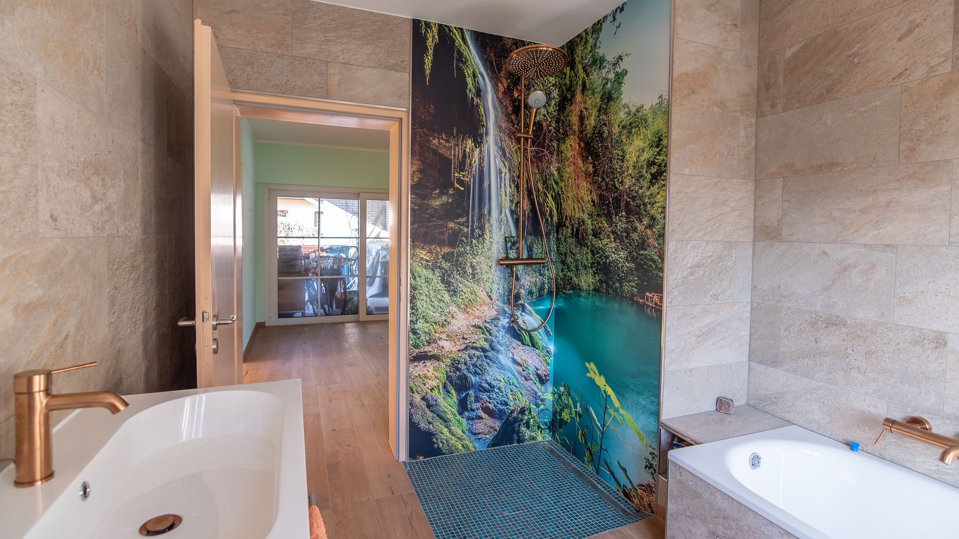 Bad mit Dusche und im Vordergrund ein Waschbecken